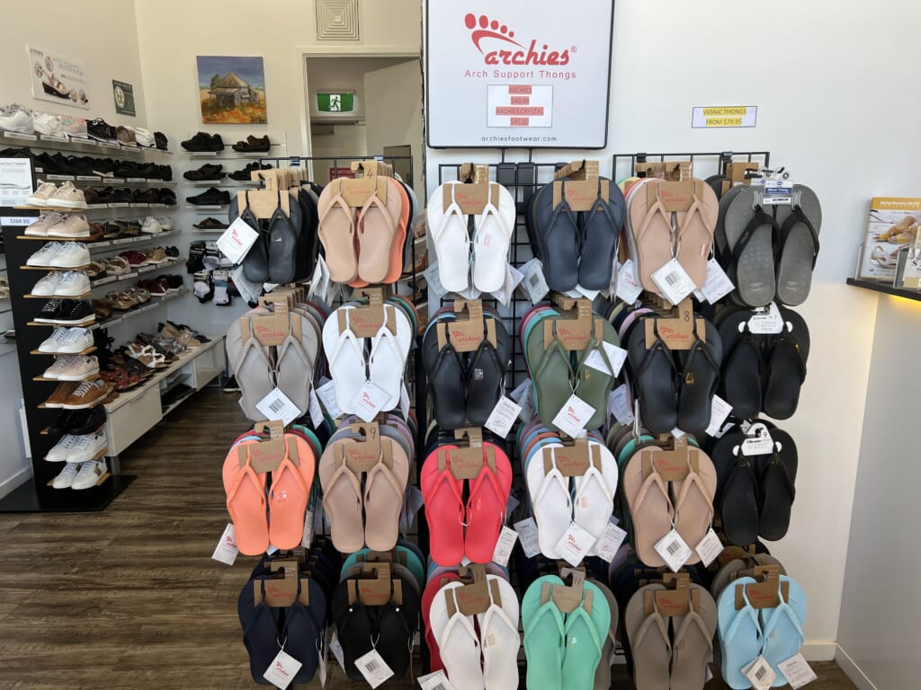 A photo of a stand with different coloured Archies which are arch support thongs