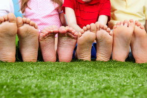 Taking care of children's feet. Children sitting in a row with feet forward.
