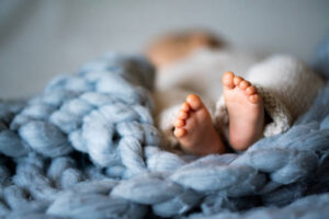 Taking care of children's feet. Baby in blanket with feet in focus.